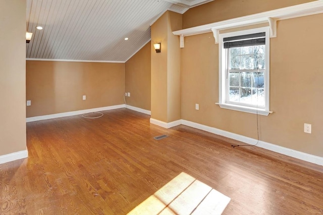 additional living space with hardwood / wood-style flooring and lofted ceiling