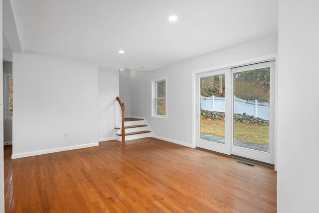 spare room with light wood-type flooring, visible vents, recessed lighting, stairs, and baseboards