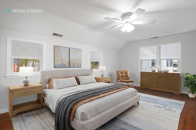 bedroom with visible vents, multiple windows, vaulted ceiling, and wood finished floors