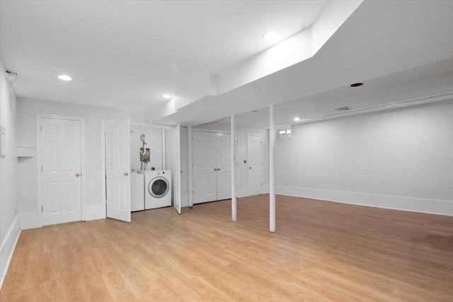 finished below grade area with recessed lighting, light wood-style flooring, baseboards, and washing machine and clothes dryer