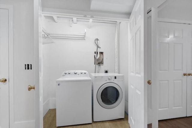 laundry room featuring laundry area, wood finished floors, and washing machine and clothes dryer