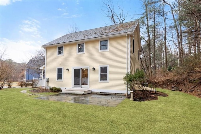 back of property featuring a patio, a yard, and roof with shingles