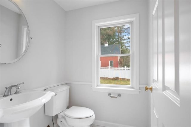 bathroom featuring baseboards, a sink, and toilet