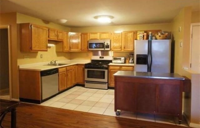 kitchen with appliances with stainless steel finishes, light tile patterned floors, and sink