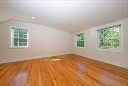 bonus room with hardwood / wood-style floors and lofted ceiling