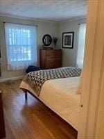 bedroom with hardwood / wood-style flooring and ornamental molding