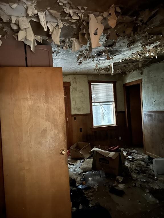 miscellaneous room with wainscoting and wood walls