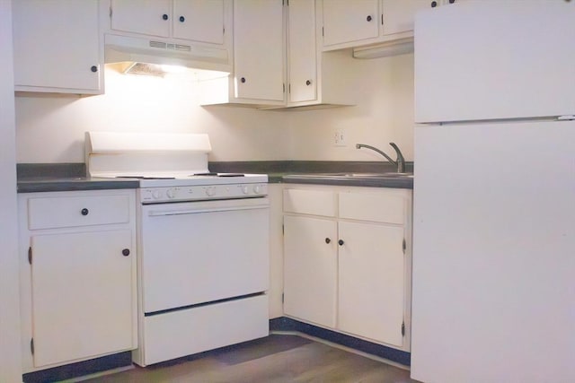 kitchen with dark countertops, white appliances, white cabinetry, and under cabinet range hood