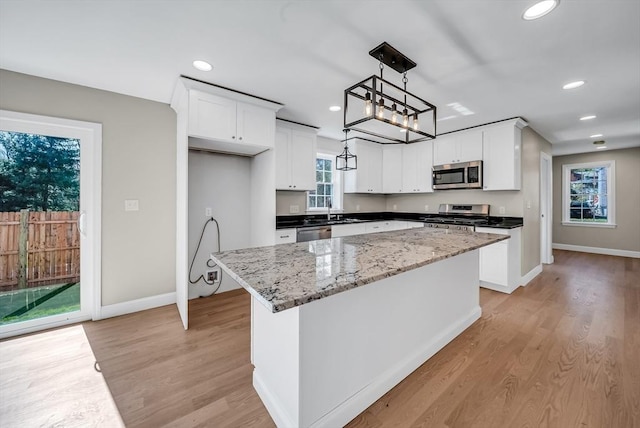 kitchen with appliances with stainless steel finishes, baseboards, and white cabinetry