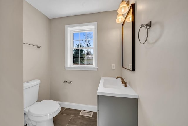 bathroom with baseboards, toilet, vanity, and tile patterned floors