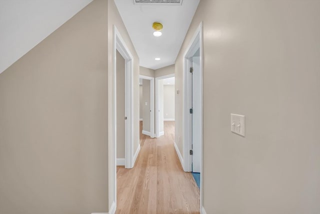 corridor featuring light wood-style floors and baseboards