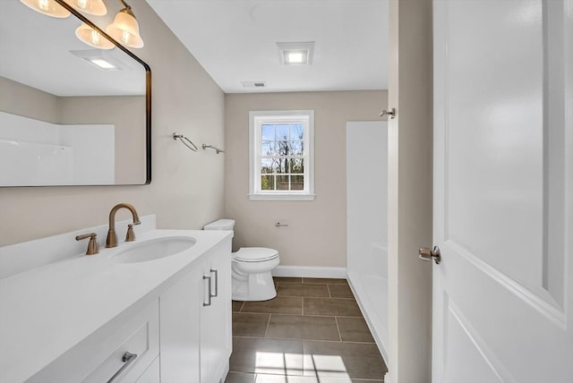 bathroom with vanity, toilet, baseboards, and tile patterned flooring