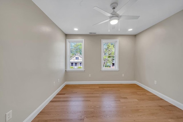 spare room with baseboards, light wood-style floors, ceiling fan, and recessed lighting
