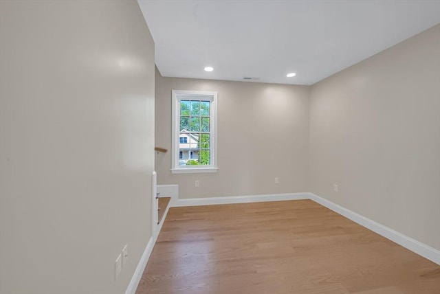 empty room with light wood-style floors, baseboards, and recessed lighting
