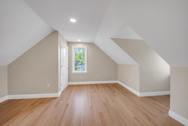 additional living space with light wood-type flooring, baseboards, vaulted ceiling, and recessed lighting