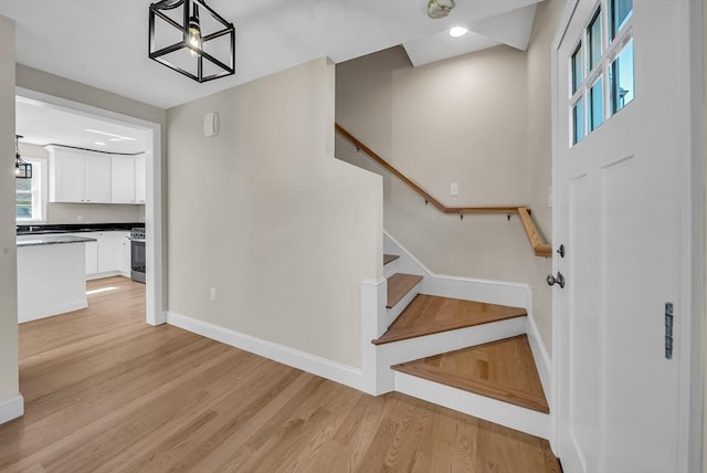 staircase featuring recessed lighting, baseboards, and wood finished floors