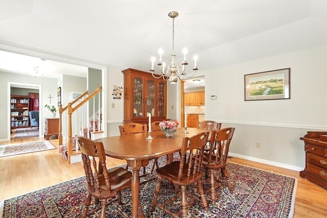 167 Orchard Rd, East Longmeadow, MA 01028 - dining room with a chandelier, light wood finished floors, stairs, and baseboards