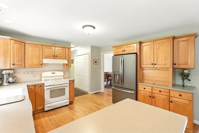 167 Orchard Rd, East Longmeadow, MA 01028 - kitchen with stainless steel refrigerator with ice dispenser, white range with gas cooktop, under cabinet range hood, and light wood-style floors