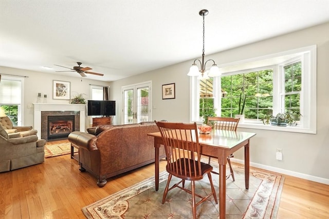 167 Orchard Rd, East Longmeadow, MA 01028 - dining space with light wood-type flooring, ceiling fan, a fireplace with flush hearth, and baseboards
