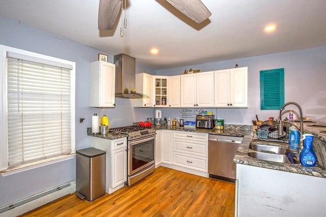 37 Border St, Springfield, MA 01104 - kitchen with appliances with stainless steel finishes, a baseboard radiator, wall chimney exhaust hood, light wood-type flooring, and recessed lighting