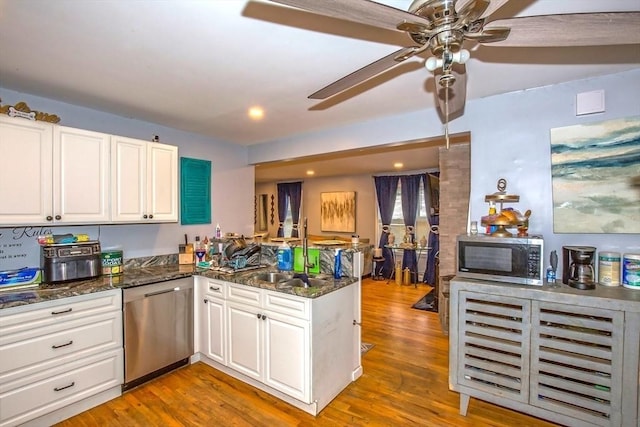 37 Border St, Springfield, MA 01104 - kitchen featuring stainless steel appliances, a peninsula, white cabinetry, ceiling fan, and wood finished floors