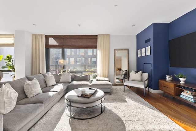 living room with visible vents, baseboards, and wood finished floors