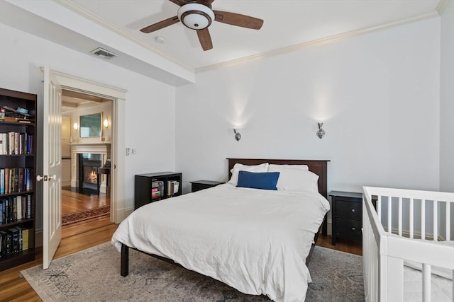 19 Woodbine St Unit B, Newton, MA 02466 - bedroom featuring a fireplace with flush hearth, wood finished floors, crown molding, and a ceiling fan