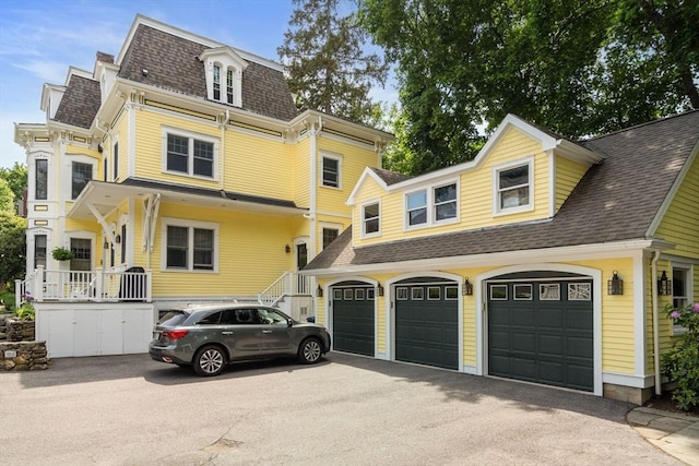 19 Woodbine St Unit B, Newton, MA 02466 - view of front facade featuring a shingled roof, asphalt driveway, and a garage