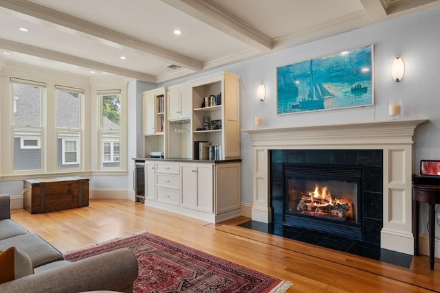 19 Woodbine St Unit B, Newton, MA 02466 - living area featuring light wood finished floors, a tiled fireplace, beamed ceiling, ornamental molding, and beverage cooler