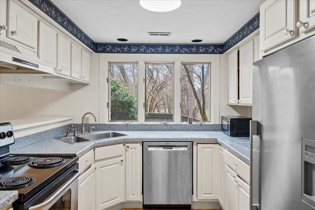 kitchen featuring visible vents, a sink, appliances with stainless steel finishes, and white cabinets