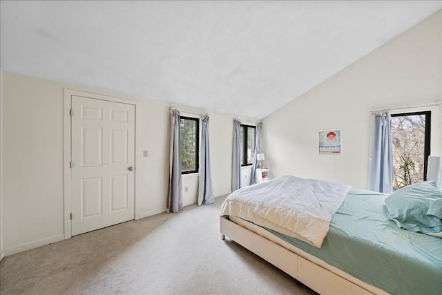 carpeted bedroom featuring baseboards and vaulted ceiling