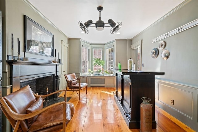 46 Church St, Dedham, MA 02026 - sitting room with a fireplace, ornamental molding, wainscoting, a notable chandelier, and light wood-type flooring
