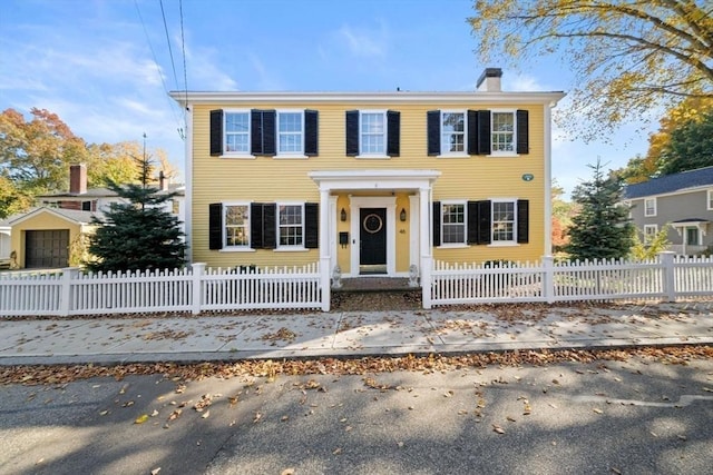 view of front of home featuring a fenced front yard and a chimney