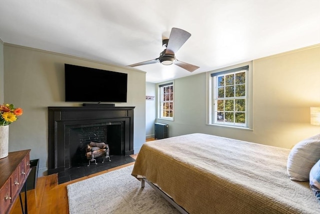 46 Church St, Dedham, MA 02026 - bedroom with a ceiling fan, radiator heating unit, wood finished floors, and a fireplace with flush hearth