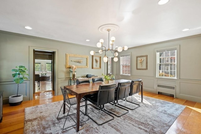 46 Church St, Dedham, MA 02026 - dining room with ornamental molding, wood finished floors, radiator heating unit, an inviting chandelier, and a decorative wall