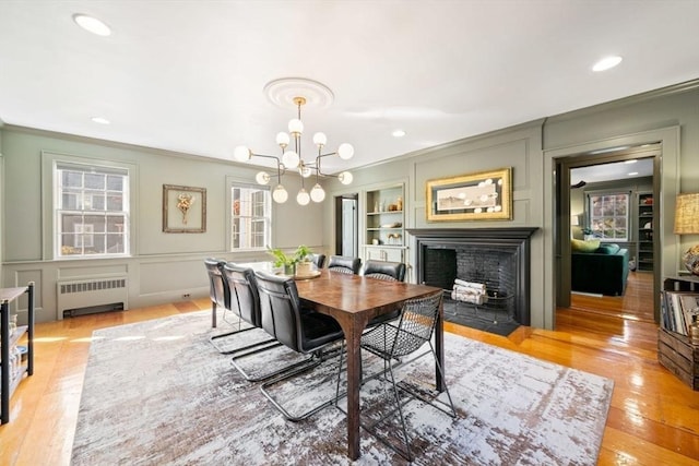 46 Church St, Dedham, MA 02026 - dining room with a decorative wall, radiator, crown molding, and a fireplace with flush hearth
