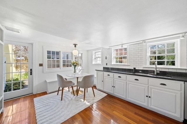 46 Church St, Dedham, MA 02026 - kitchen featuring dark countertops, hardwood / wood-style floors, tasteful backsplash, and a sink