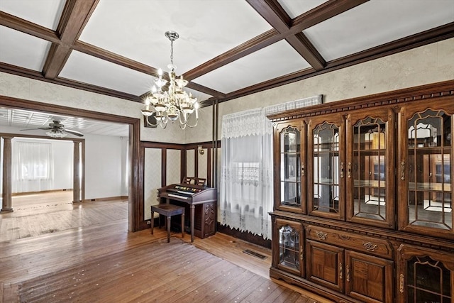 dining area featuring ceiling fan with notable chandelier, beam ceiling, wood-type flooring, and coffered ceiling