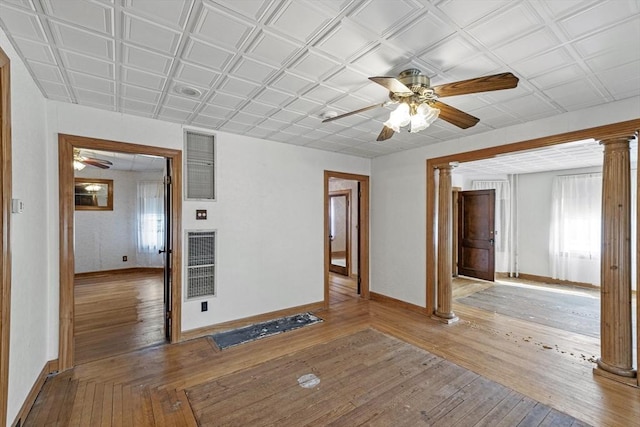 unfurnished room with ceiling fan, light wood-type flooring, and ornate columns