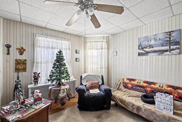 living area featuring carpet flooring and ceiling fan