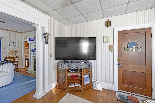 living room featuring wood-type flooring, ornate columns, and ornamental molding