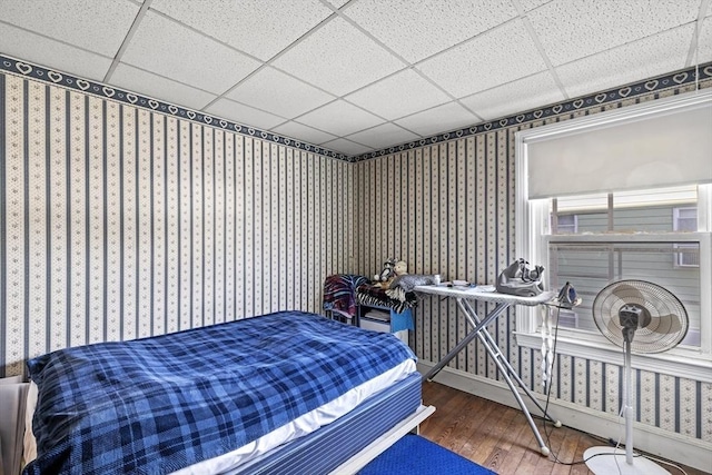 bedroom with a paneled ceiling and dark hardwood / wood-style floors