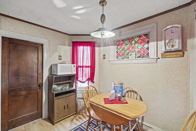 dining space featuring light hardwood / wood-style flooring and ornamental molding