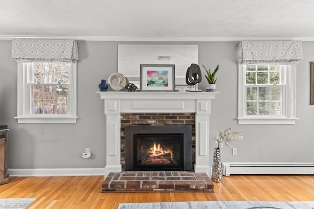 details with a brick fireplace, crown molding, baseboard heating, and wood finished floors