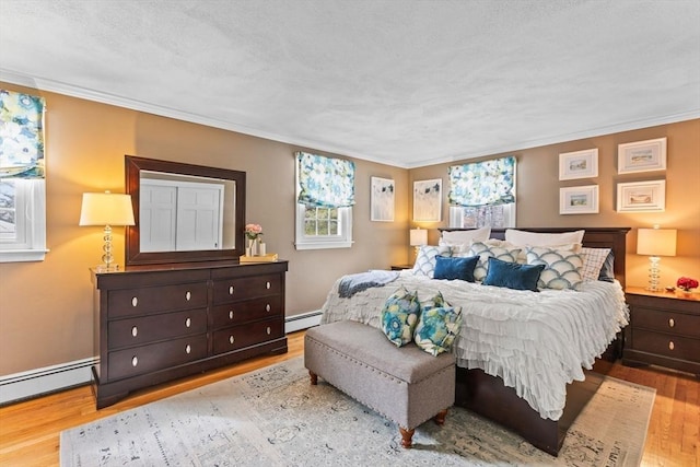 bedroom with light wood finished floors, baseboards, a baseboard heating unit, and ornamental molding