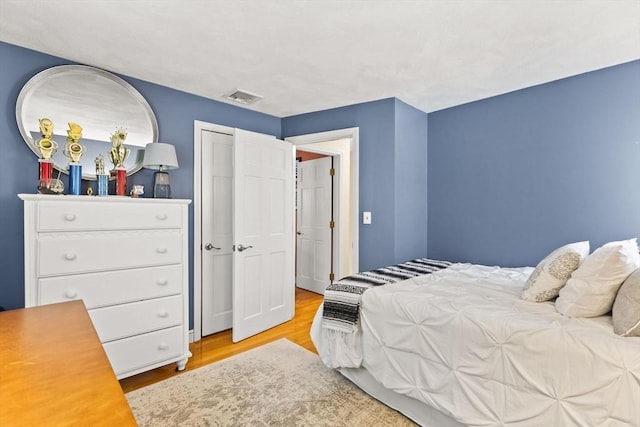 bedroom featuring light wood finished floors and visible vents