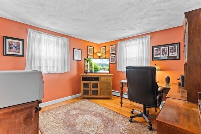 office featuring baseboards, a textured ceiling, a baseboard heating unit, and wood finished floors