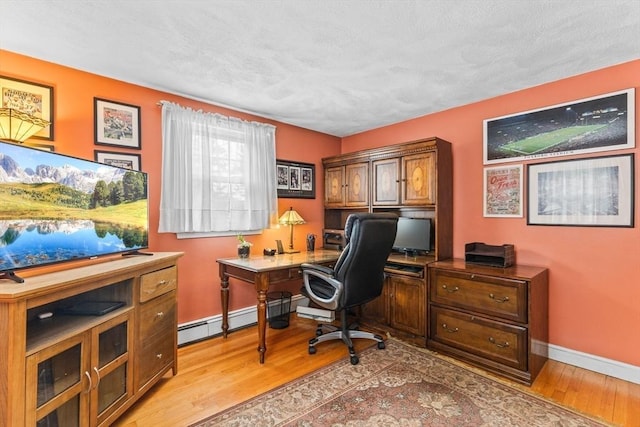 office space featuring light wood-type flooring, a baseboard radiator, and baseboards