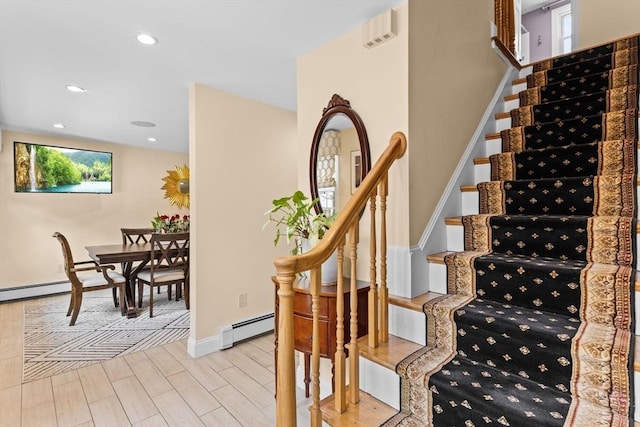 staircase featuring baseboards, a baseboard radiator, wood finished floors, and recessed lighting