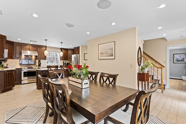 dining space with light wood-type flooring and recessed lighting